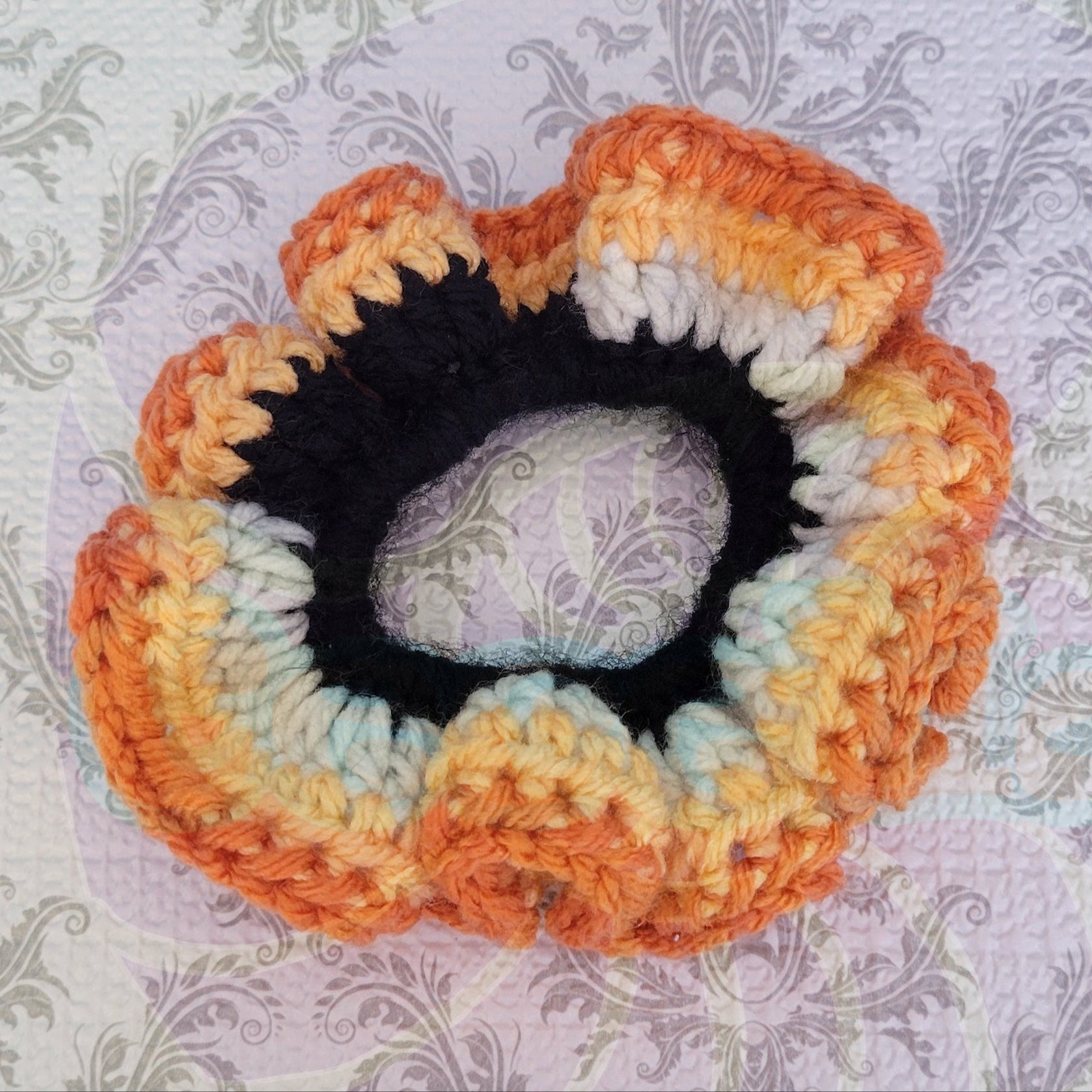 Crochet Scrunchy on orange, white and black with A Tiger Pattern.