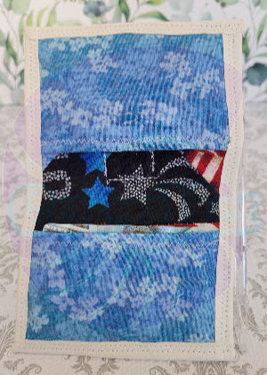 Quilted fabric square with blue floral pattern and black fabric with star design on a floral background