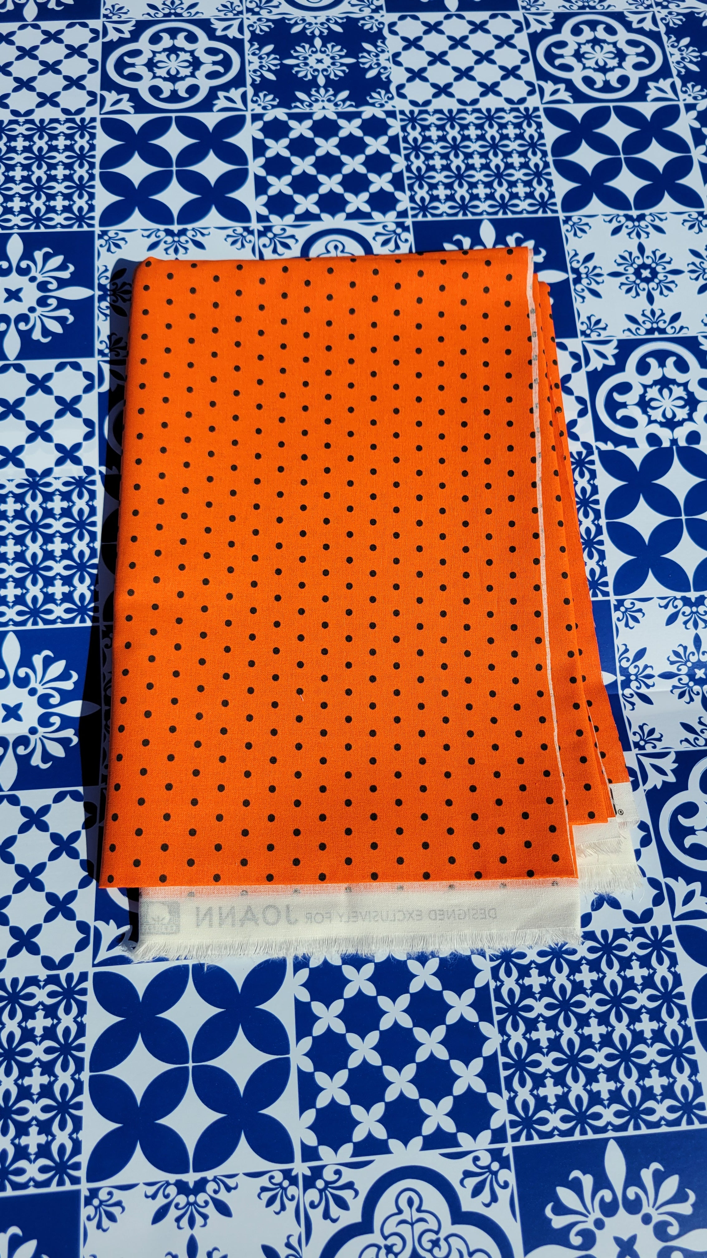 Black polka dot pattern on Orange Fabric.