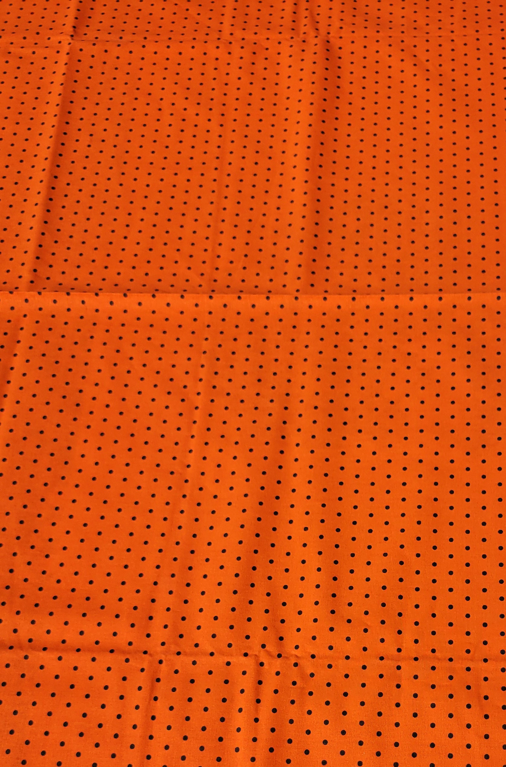 Black polka dot pattern on Orange Fabric.