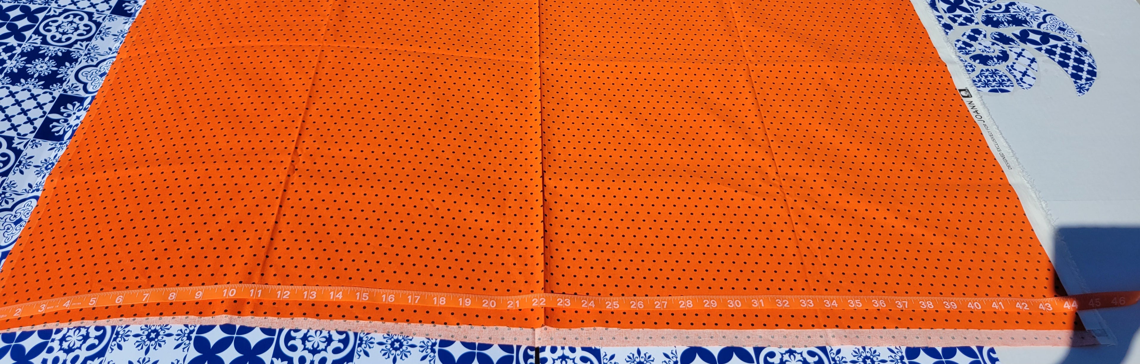 Black polka dot pattern on Orange Fabric.