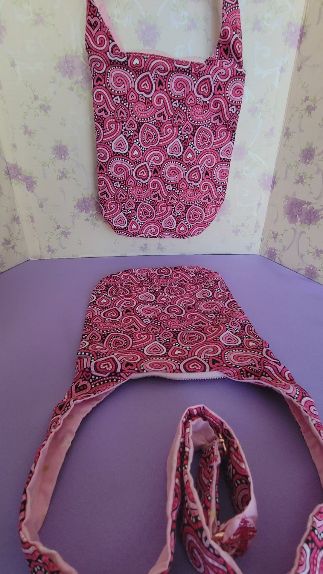 Showing how many items can fit the Angelica Purse. So far there is a book in size 6, travel size hand sanitiser, a pair of keys, a wallet, and a pen.